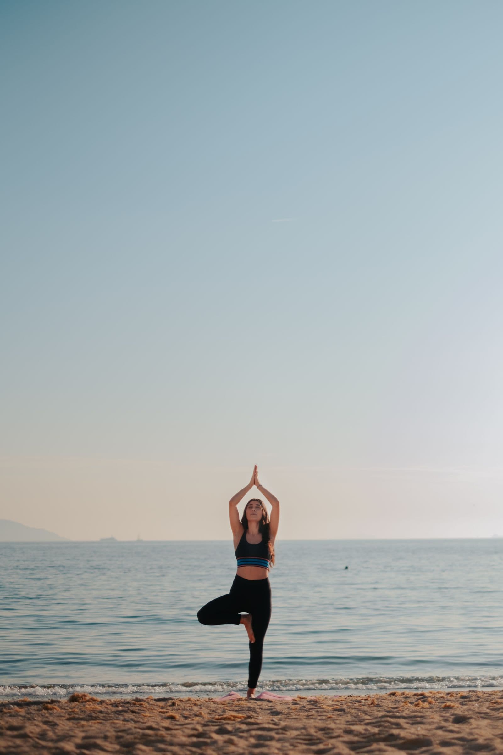Bodrum sahilinde gün doğumunda yoga yapan kadın